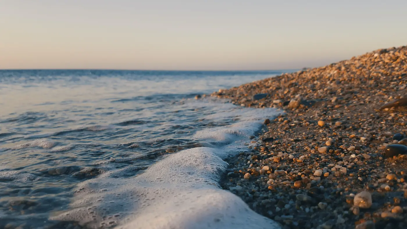 Wave breaking onto shingle. Photo by Giuseppe Famiani on Unsplash